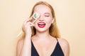 Girl in a black dress on a beige background. Woman eating Philadelphia sushi. A girl with red lipstick holds chopsticks for sushi Royalty Free Stock Photo