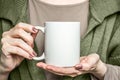 Girl in black dress is holding white mug. Mockup for Halloween gifts design.