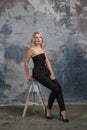 Girl ir sitting on a high chair next to a wall Royalty Free Stock Photo