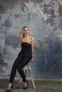 Girl ir sitting on a high chair next to a wall Royalty Free Stock Photo