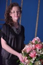 Girl in a black dress next to a vase with flowers Royalty Free Stock Photo