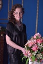 Girl in a black dress next to a vase with flowers Royalty Free Stock Photo