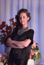 Girl in a black dress next to a vase with flowers Royalty Free Stock Photo