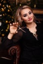 Girl in a black dress with scissors in her hands. preparation for the new year, christmas. hairstyle. tidy yourself up.