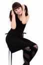 Girl in black dress sitting on a high chair Royalty Free Stock Photo