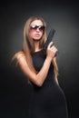 Girl in a black dress and Sunglasses holding a gun Royalty Free Stock Photo