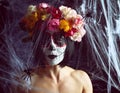 Girl with black hair is dressed in a wreath of multi-colored roses and makeup is made on her face Sugar skull to the day of the Royalty Free Stock Photo