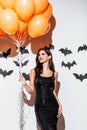 Girl in black halloween costume holding orange balloons Royalty Free Stock Photo