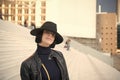 Girl in black hat and jacket pose on stairs