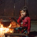 Girl from Black Hmong tribe sitting by fire