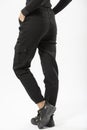 girl in black military trousers and black sports sneakers