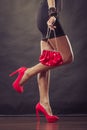 Girl in black short dress red spiked shoes holds handbag Royalty Free Stock Photo