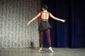 A girl in a black skirt is dancing on stage. Speech by a teenager in a dance class.