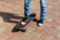 Girl in black sneakers on a skateboard. Feet on a skateboard