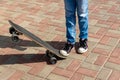 Girl in black sneakers on a skateboard. Feet on a skateboard