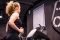 A girl in a black sports uniform runs on a treadmill in a sports hall Royalty Free Stock Photo