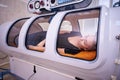 A girl in a black T-shirt lies in a hyperbaric chamber, oxygen therapy Royalty Free Stock Photo