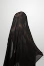 Girl in a black transparent veil on the face. Conceptual portrait in the studio.