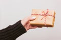 Girl in a black woolen sweater holds a Christmas gift