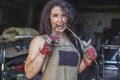 Girl blacksmith bites a curved metal rod