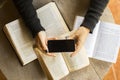 Girl with blank cell phone and books Royalty Free Stock Photo