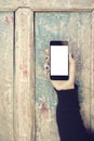 Girl with blank cell phone on a vintage wooden background Royalty Free Stock Photo