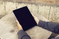 Girl with blank digital tablet screen and wooden table outdoor