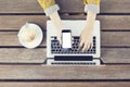 Girl with blank smartphone, laptop and cappuccino on wooden table Royalty Free Stock Photo