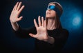 A girl blindfolded, with a blue ribbon, looking for something with her hands, playing , entertainment, a riddle