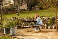 Girl blogger with camera sitting at table in yard of village house in Provence Royalty Free Stock Photo
