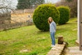 Girl blogger with camera walks in yard of a village house in Provence Royalty Free Stock Photo