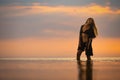 A girl with blond chic hair in a black bikini and a lace shawl walks along the estuary Royalty Free Stock Photo