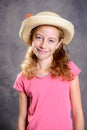 Girl with blond hair in pink shirt and straw hat Royalty Free Stock Photo