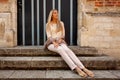 Girl sitting stairs medieval Romanesque door evening sun Royalty Free Stock Photo