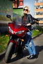 The girl blonde about a red motorcycle Royalty Free Stock Photo