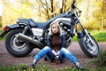 The girl blonde sits about a big motorcycle Royalty Free Stock Photo