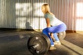 Girl blonde in a T-shirt and blue leggings in a pose on the side