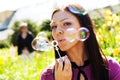 Girl blow soap bubble against a background grass Royalty Free Stock Photo