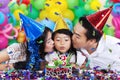 Girl blowing birthday candle with parents Royalty Free Stock Photo