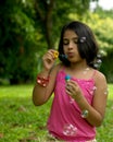 Girl blowing bubbles in the garden