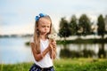 Girl blowing on dandelion, summer in nature