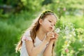 girl blowing dandelions flower selective focus. Allergy season.