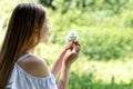 Girl blowing dandelions flower selective focus. Dandelion wishing blowing seeds. Allergy season. Royalty Free Stock Photo