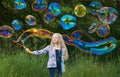 Girl blowing giant rainbow color soap bubbles