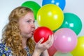 Girl blowing inflating colored balloon