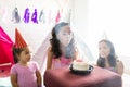 Girl Blowing Out Candles On Birthday Cake By Friends Royalty Free Stock Photo