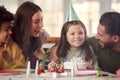 Girl Blowing Out Candles On Birthday Cake At Party With Parents And Friends At Home Royalty Free Stock Photo
