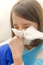 Girl blowing snot into the napkin. Sneeze. Little tired ill child sneezing with her eyes closed Royalty Free Stock Photo