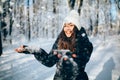 Girl Blowing Snow outdors in the forest catch snowflakes and smile