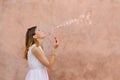 Girl blowing soap bubbles against colourful backdrop Royalty Free Stock Photo